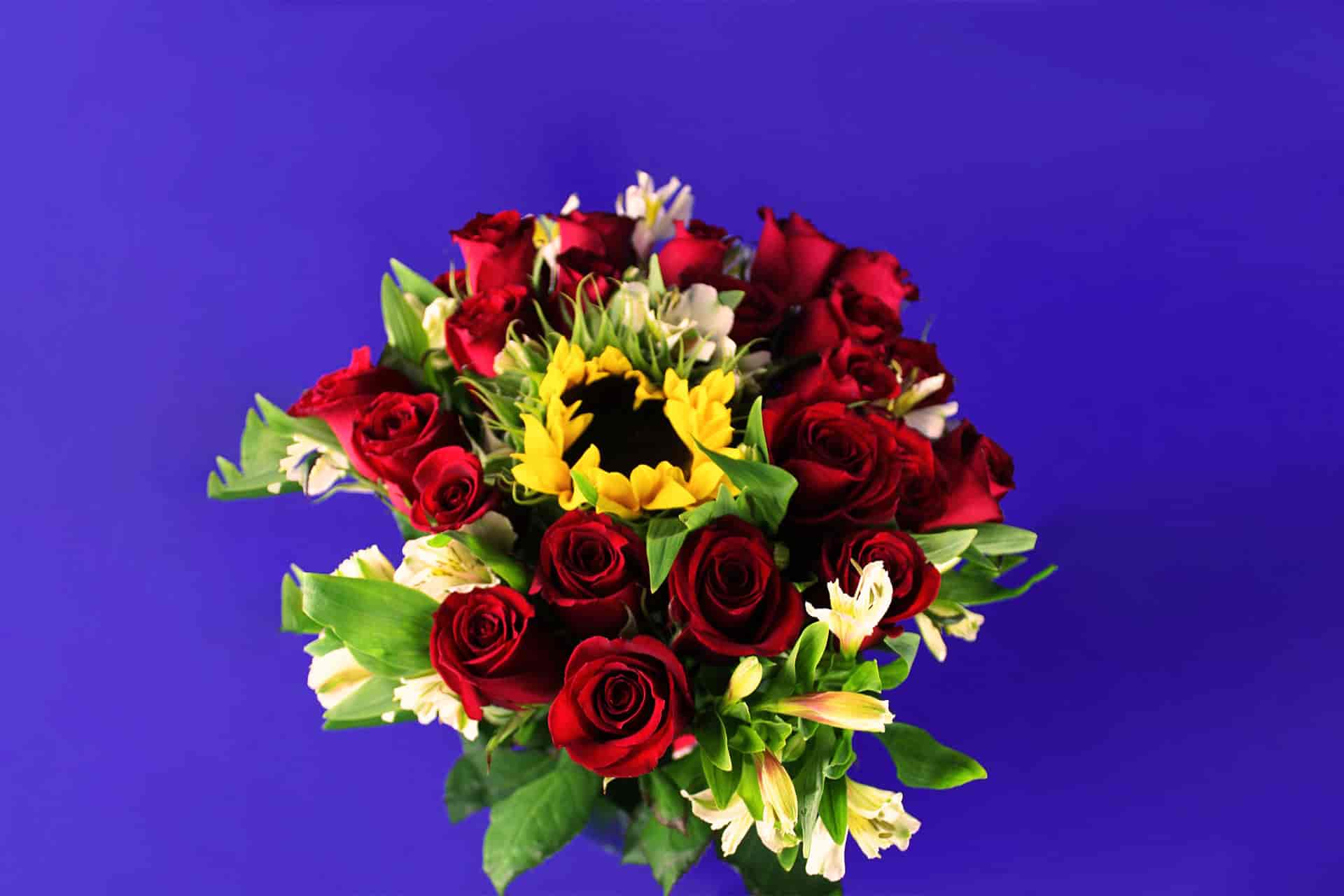 jarrón con rosas y girasoles