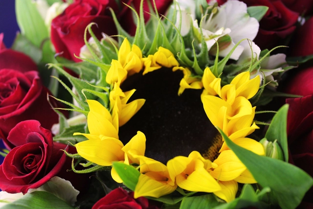 Jarrón de vidrio con 24 Rosas rojas y un Girasol